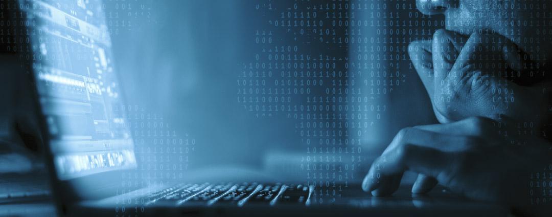 Mystic Stealer Revisited Person in front of computer, looking at code