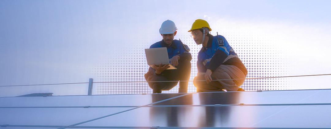 Two people in hardhats using a laptop Two people in hardhats using a laptop