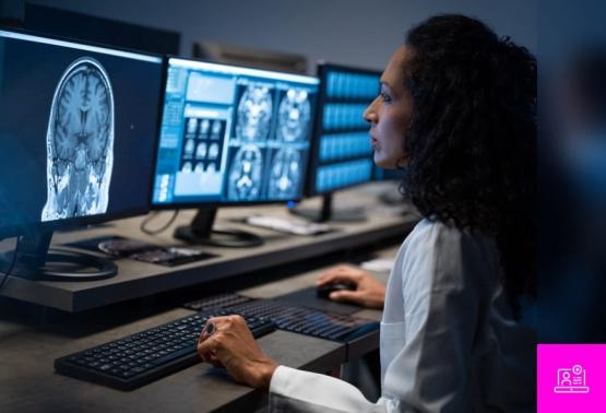 A woman in a lab coat studies a computer screen, emphasizing secure remote access solutions for the industry via an app.