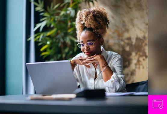 A woman with glasses sits at a desk, focused on her laptop, amidst discussions on evolving malware threats.