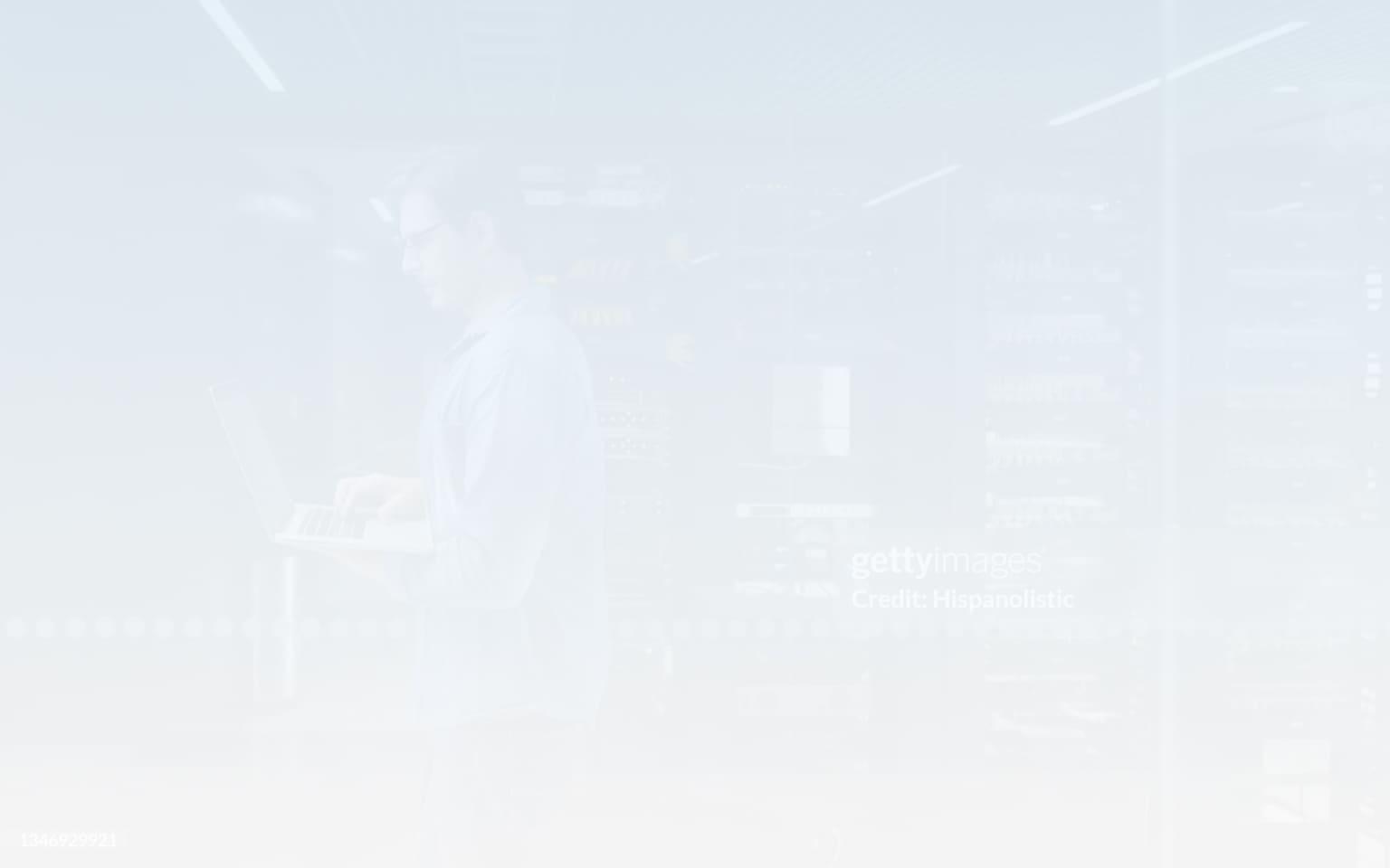 A man stands before a computer and laptop, exploring malware information and strategies to safeguard against cyber threats.