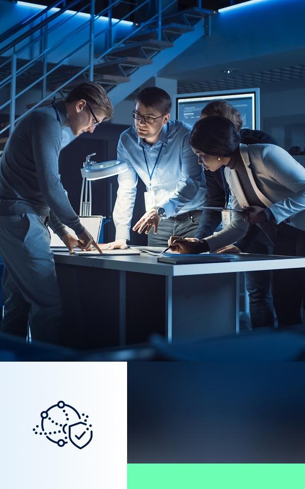 A group of professionals engaged with a laptop in an office, highlighting collaboration and effective asset management strategies.
