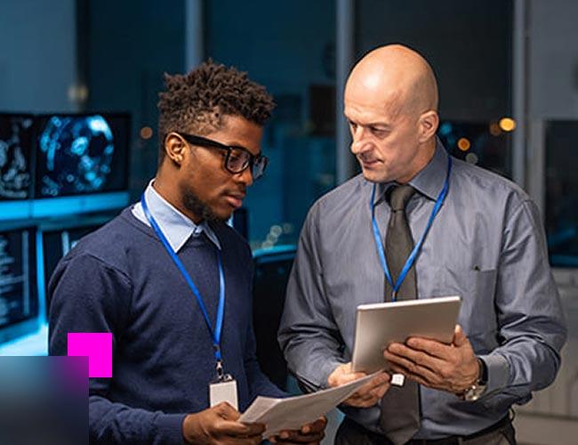 Two men looking at a tablet while learning about data security